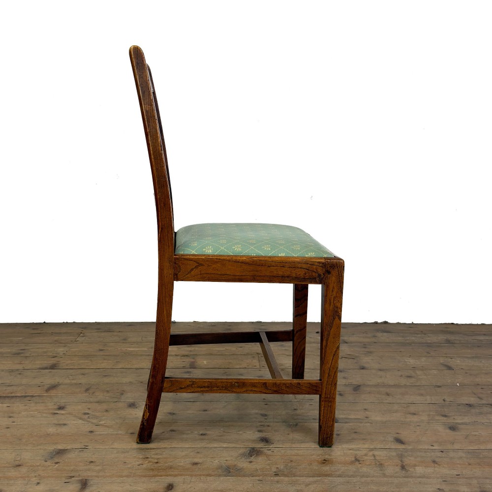 A set of six antique oak dining chairs, including two carvers, featuring geometric inlaid crest rails, decorative back splats, and light green patterned fabric seats. View IX