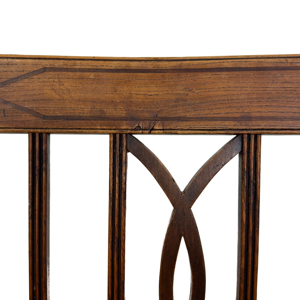 A set of six antique oak dining chairs, including two carvers, featuring geometric inlaid crest rails, decorative back splats, and light green patterned fabric seats. View XII