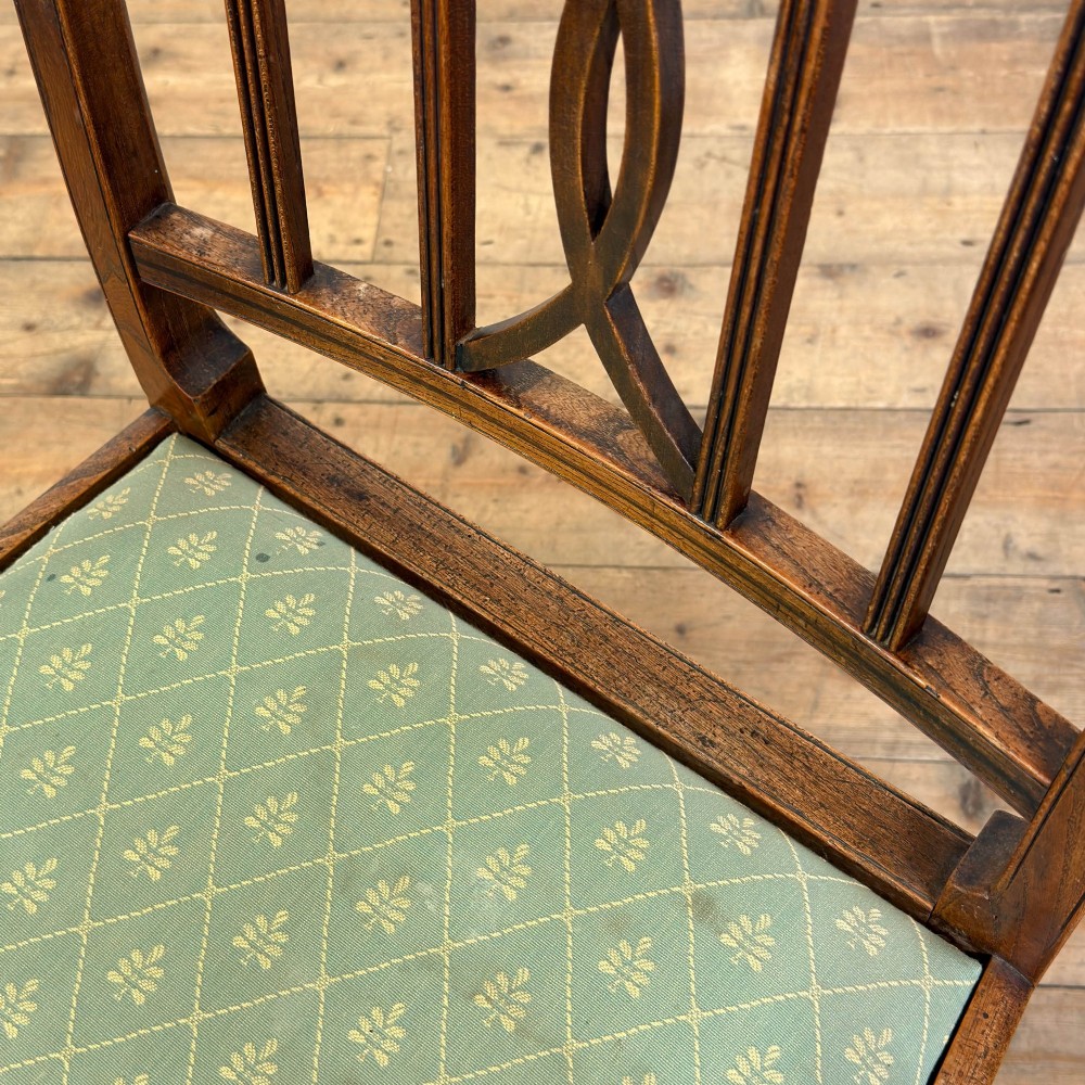 A set of six antique oak dining chairs, including two carvers, featuring geometric inlaid crest rails, decorative back splats, and light green patterned fabric seats. View XIII