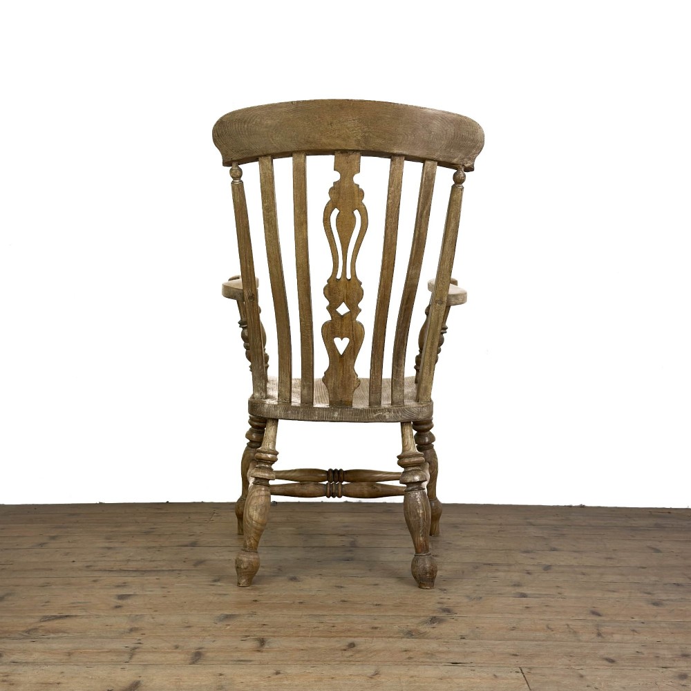 A traditional wooden Windsor armchair featuring a pierced back splat, turned arm supports, and a shaped saddle seat. View II