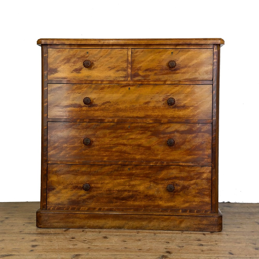 A Victorian mahogany chest of drawers featuring two short over three long drawers with carved fluted knobs and a plinth base.