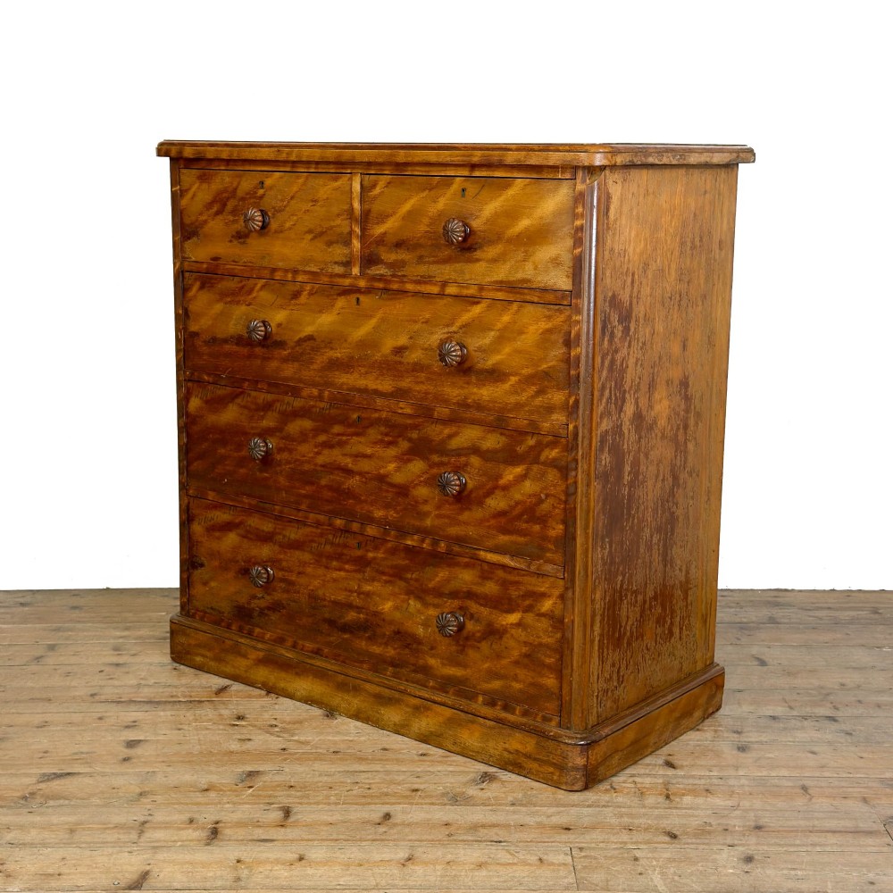A Victorian mahogany chest of drawers featuring two short over three long drawers with carved fluted knobs and a plinth base. View II