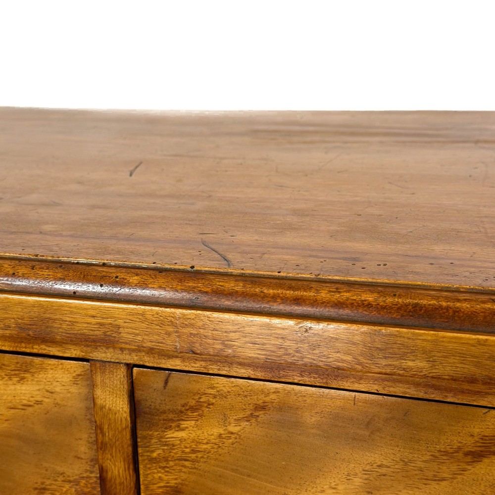 A Victorian mahogany chest of drawers featuring two short over three long drawers with carved fluted knobs and a plinth base. View III