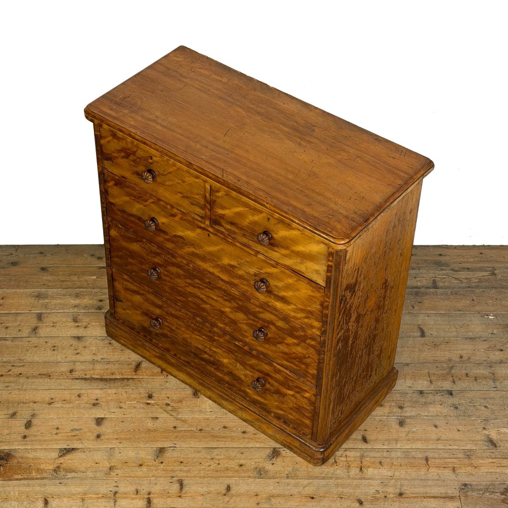 A Victorian mahogany chest of drawers featuring two short over three long drawers with carved fluted knobs and a plinth base. View IV