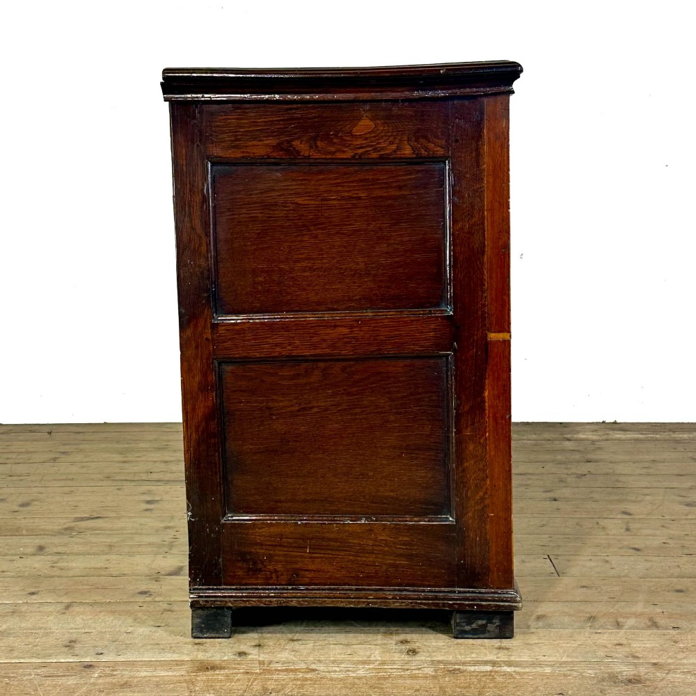An antique Georgian oak dresser base featuring brass oval drop handles, panelled cupboard doors, central drawers, and geometric diamond inlay. View VI