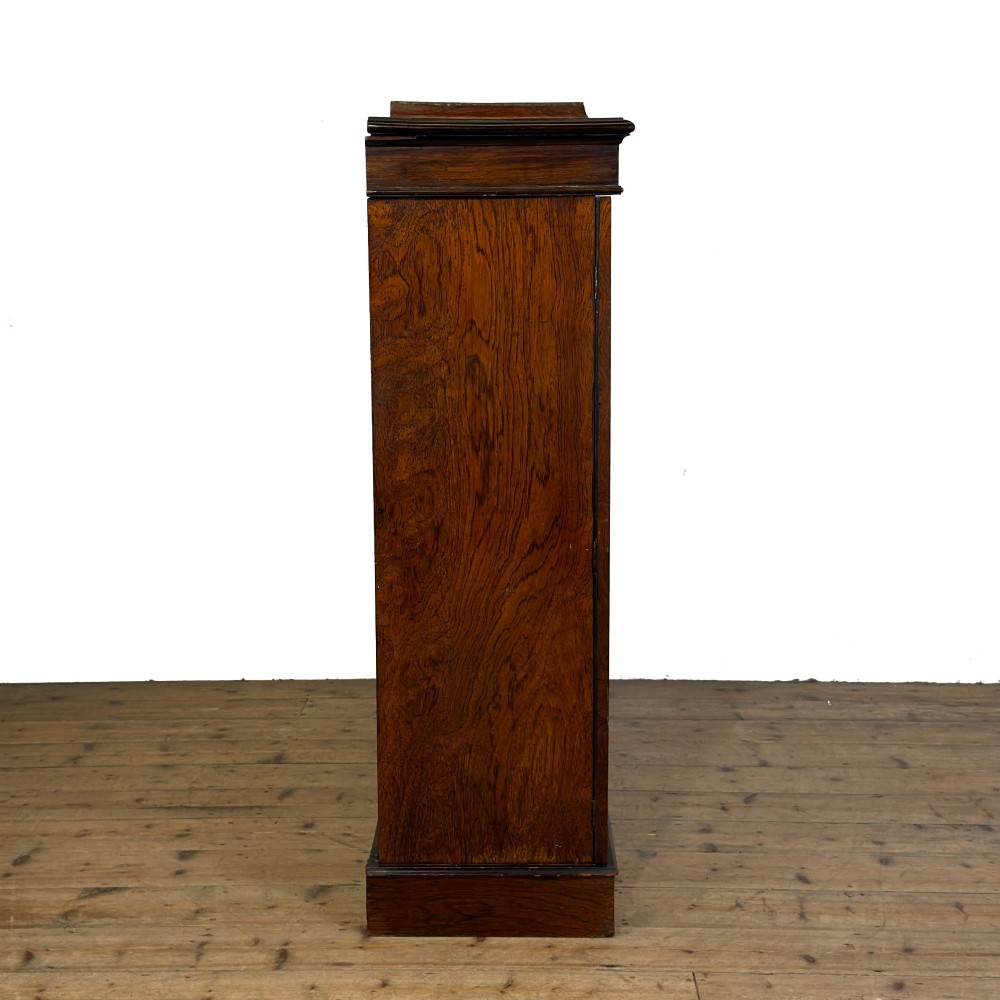 An Edwardian dark mahogany display cabinet featuring two glazed doors, satinwood scroll marquetry along the top frieze, and internal wooden shelves. View IV