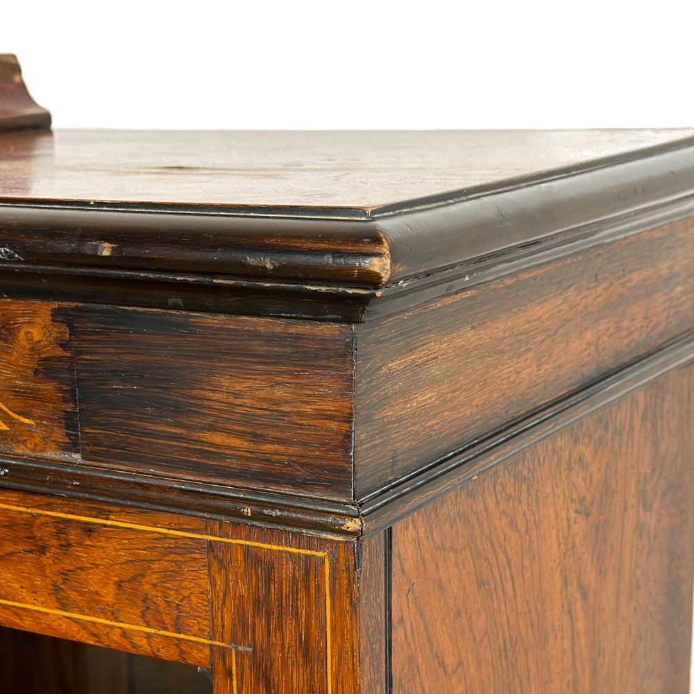 An Edwardian dark mahogany display cabinet featuring two glazed doors, satinwood scroll marquetry along the top frieze, and internal wooden shelves. View X