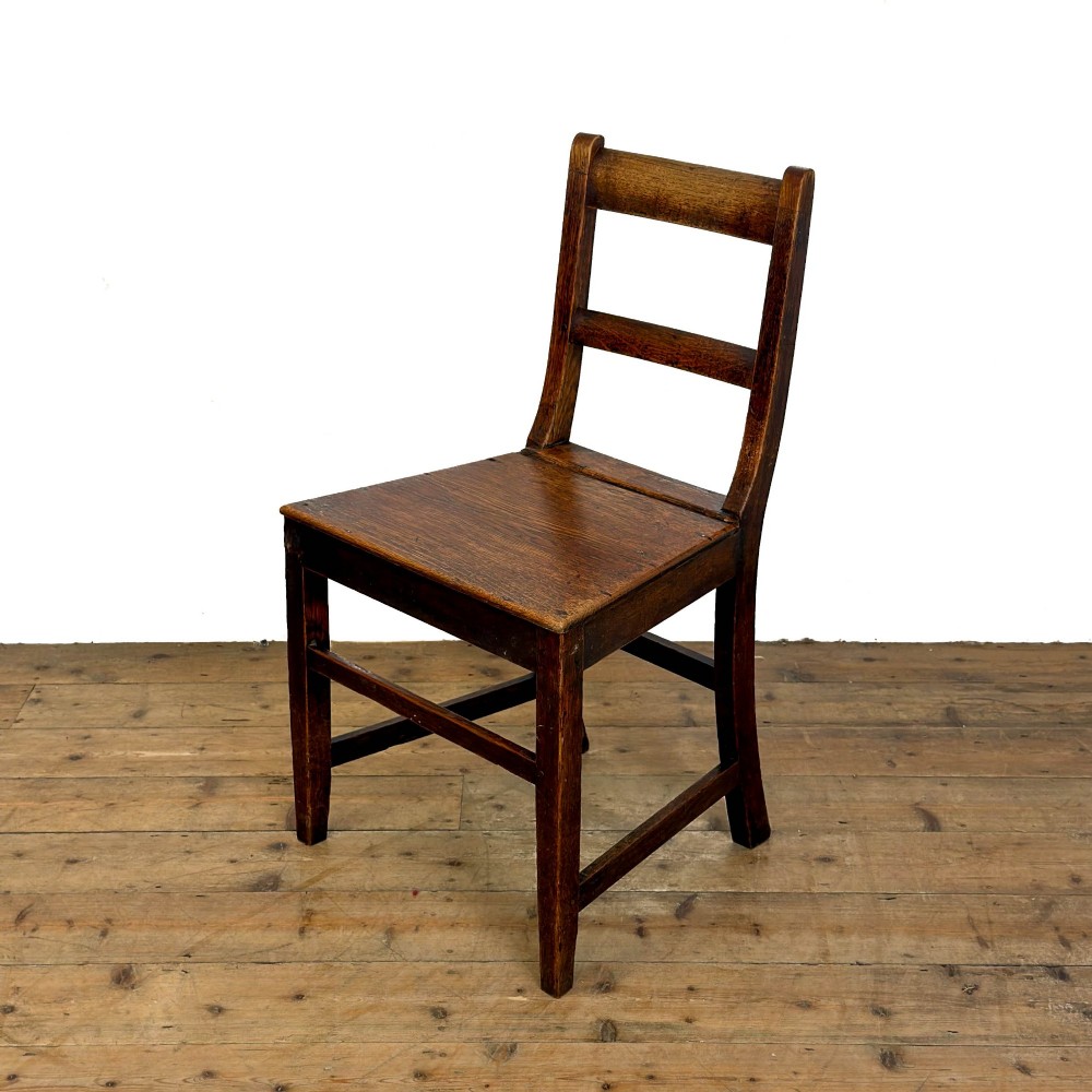 A harlequin set of four dark brown oak country dining chairs featuring horizontal ladder backs and solid wood seats on square legs. View IV