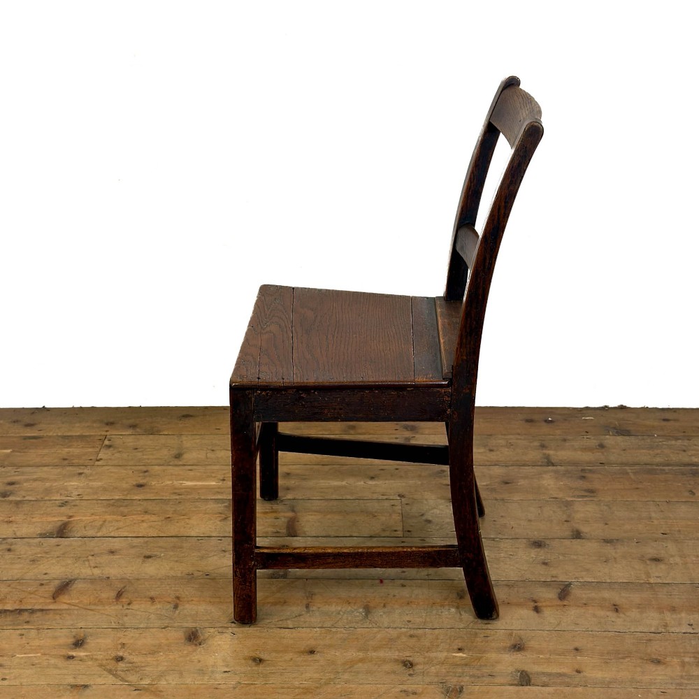 A harlequin set of four dark brown oak country dining chairs featuring horizontal ladder backs and solid wood seats on square legs. View VI