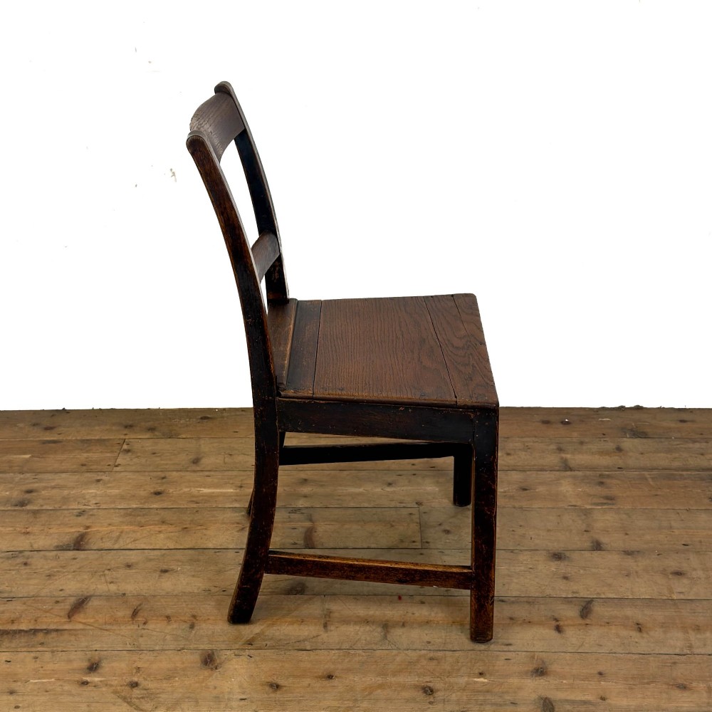 A harlequin set of four dark brown oak country dining chairs featuring horizontal ladder backs and solid wood seats on square legs. View IX