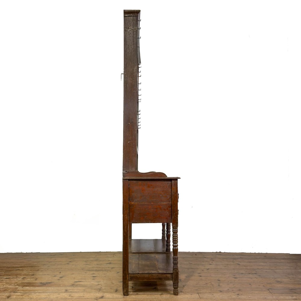 A 19th-century dark oak Welsh potboard dresser featuring an open three-shelf plate rack resting on a five-drawer base with turned legs. View VIII