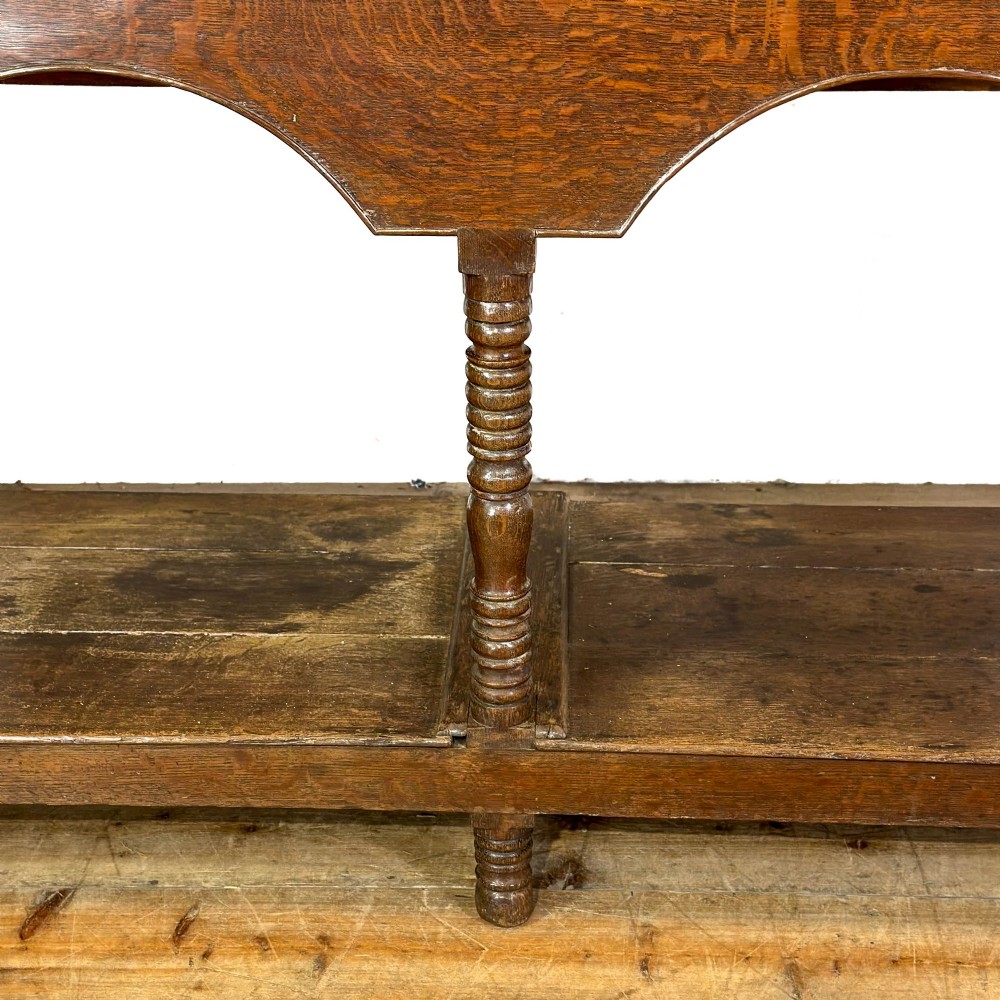 A 19th-century dark oak Welsh potboard dresser featuring an open three-shelf plate rack resting on a five-drawer base with turned legs. View IX
