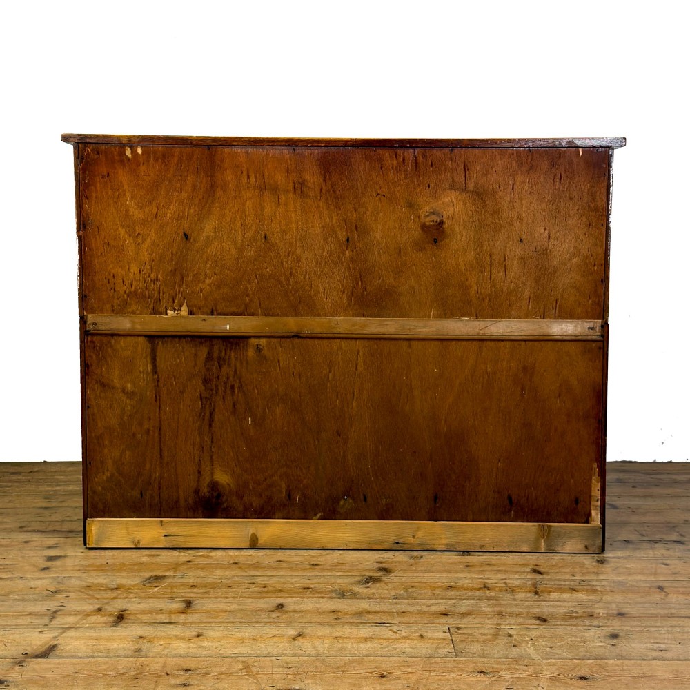 A vintage pale oak chest of drawers featuring four small top drawers above three wide drawers, fitted with dark metal cup handles. View V