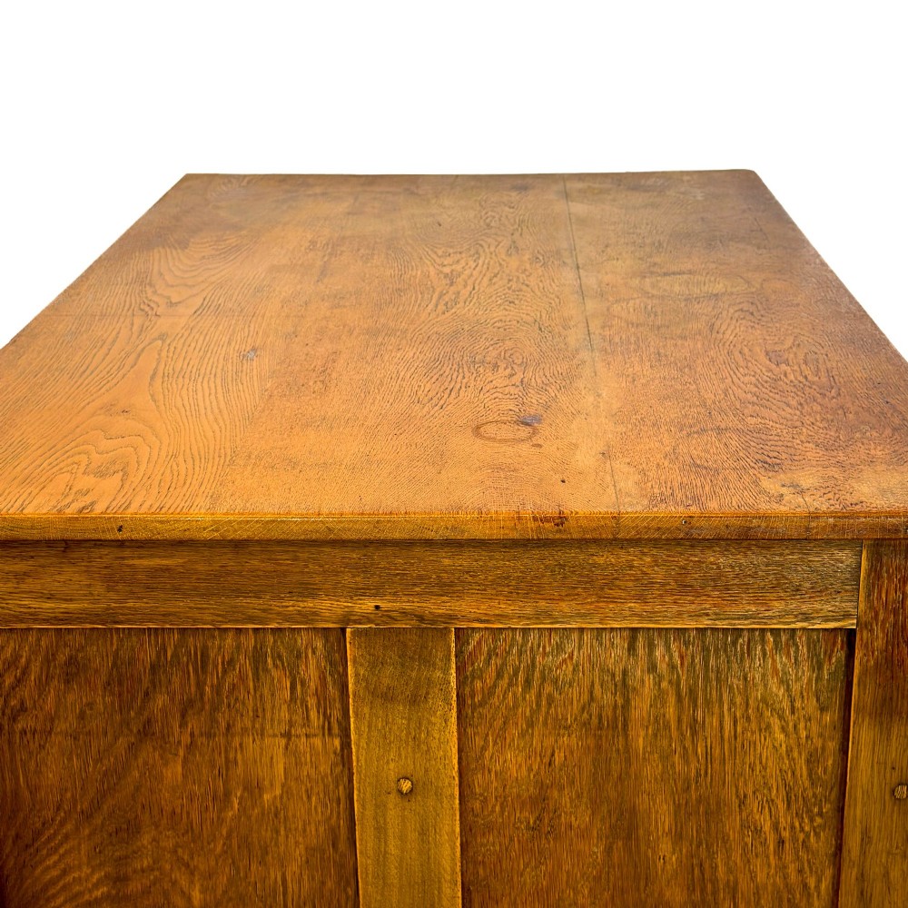 A vintage pale oak chest of drawers featuring four small top drawers above three wide drawers, fitted with dark metal cup handles. View VII