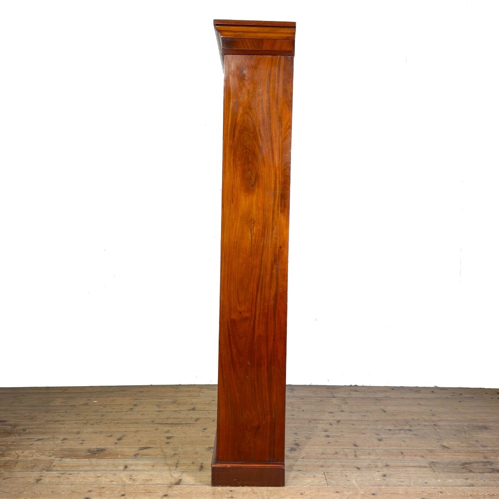 A large antique open mahogany bookcase with a moulded top cornice, multiple storage shelves, and vertical panelled timber backing. View IV