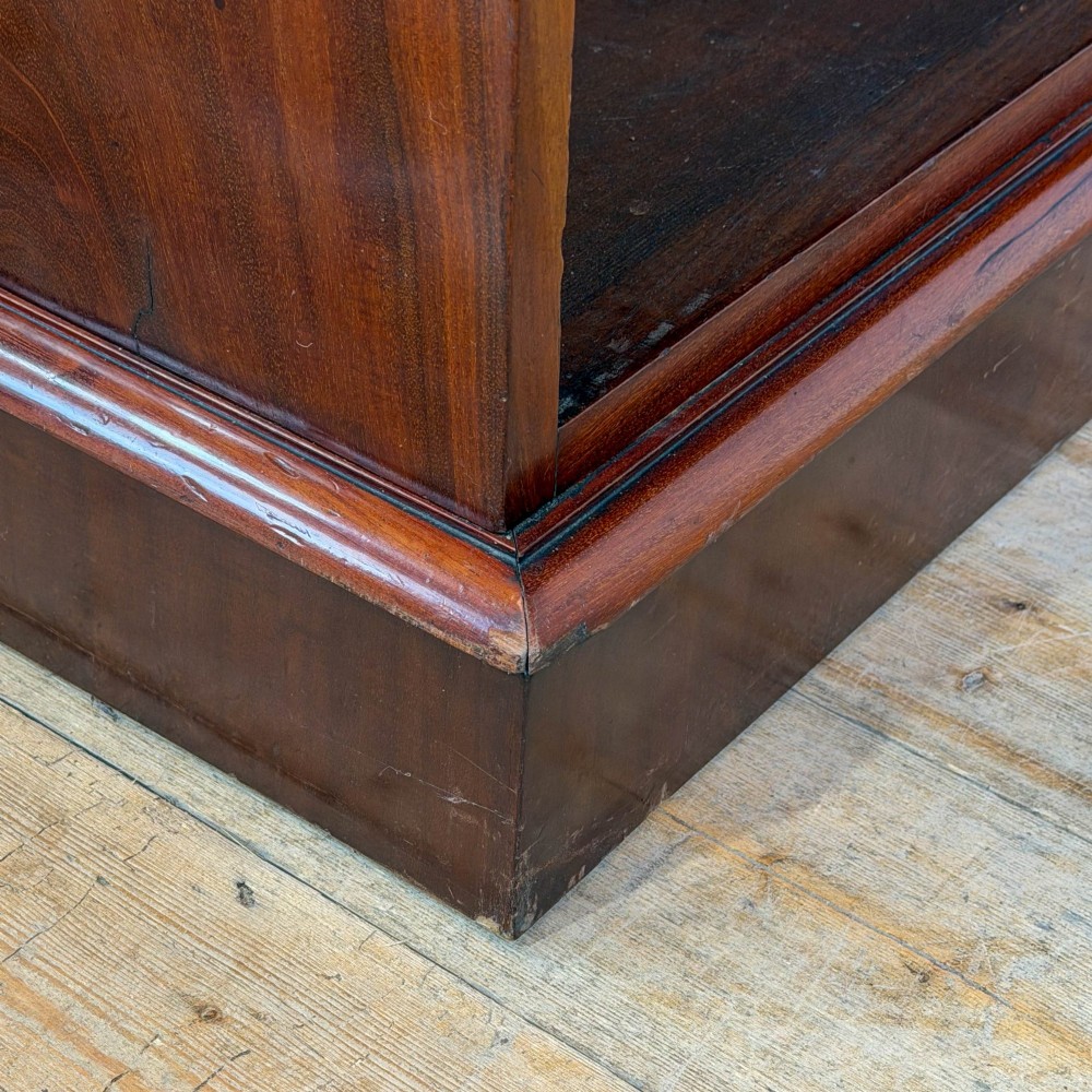 A large antique open mahogany bookcase with a moulded top cornice, multiple storage shelves, and vertical panelled timber backing. View VI