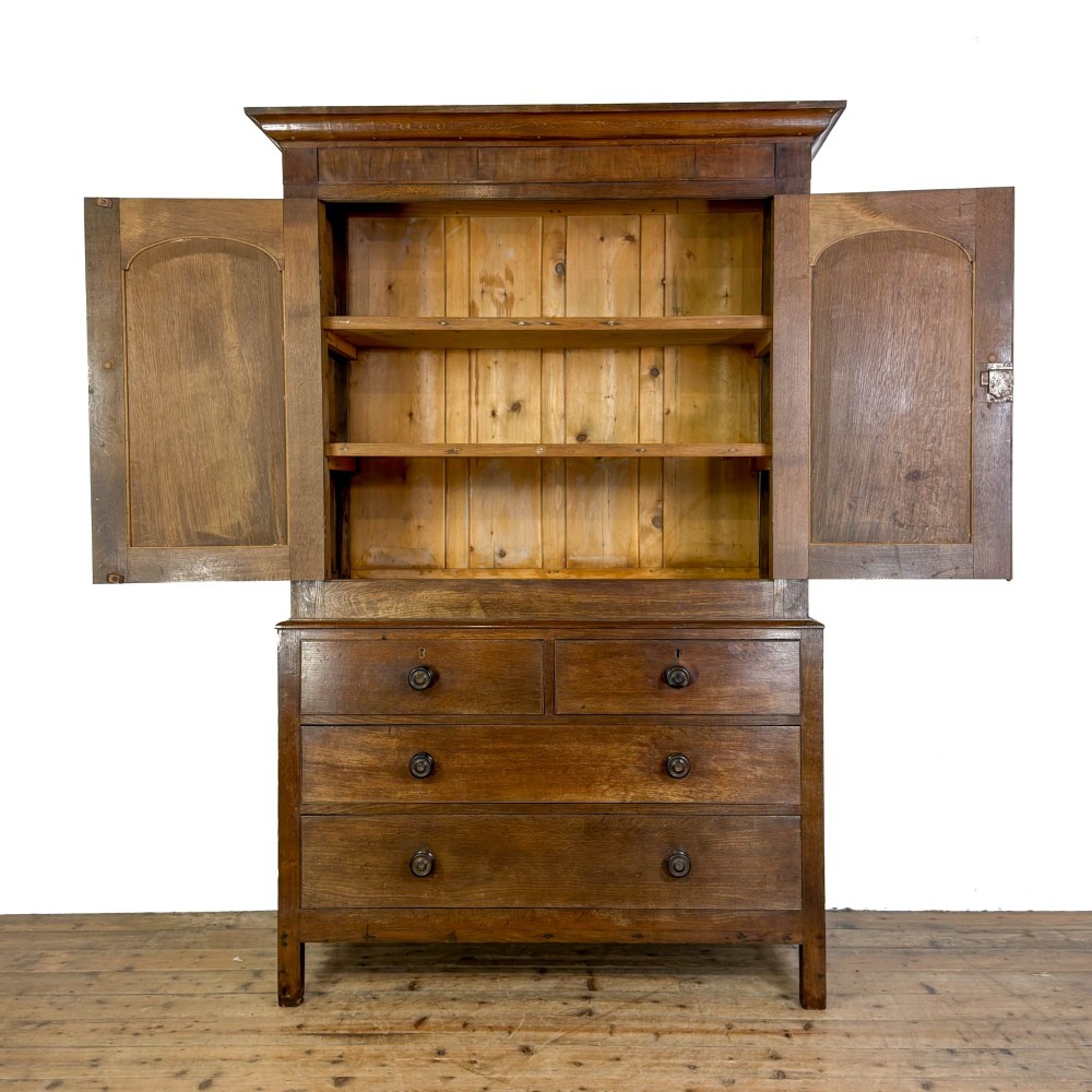 A 19th-century oak linen press featuring a two-door upper cupboard flanked by barley twist columns above a chest of drawers. View II