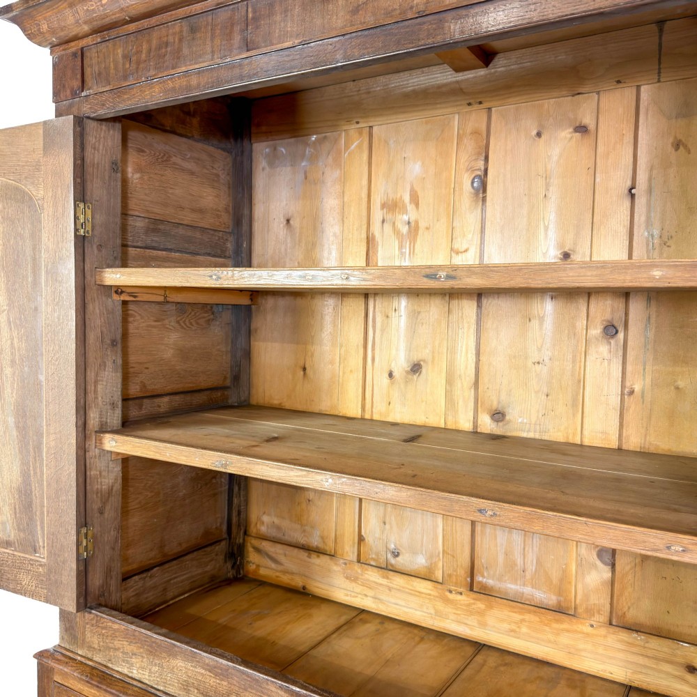 A 19th-century oak linen press featuring a two-door upper cupboard flanked by barley twist columns above a chest of drawers. View III