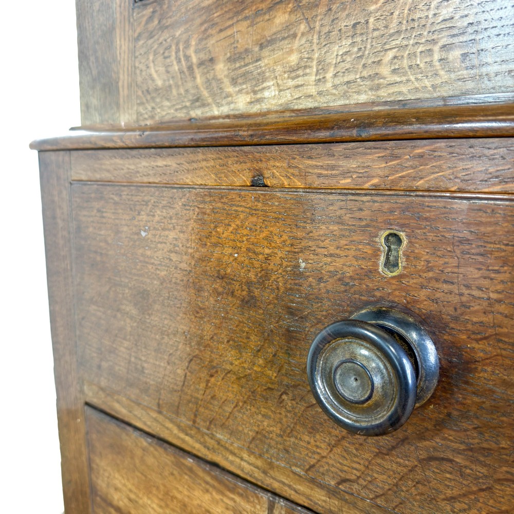 A 19th-century oak linen press featuring a two-door upper cupboard flanked by barley twist columns above a chest of drawers. View V