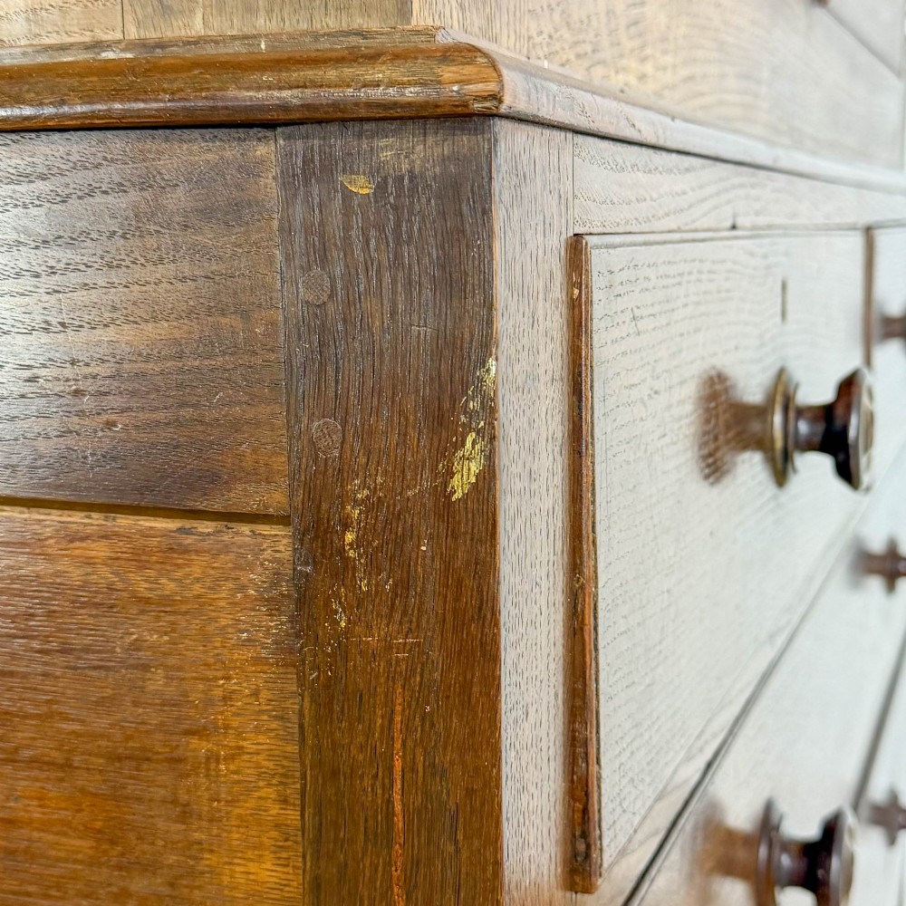 A 19th-century oak linen press featuring a two-door upper cupboard flanked by barley twist columns above a chest of drawers. View X