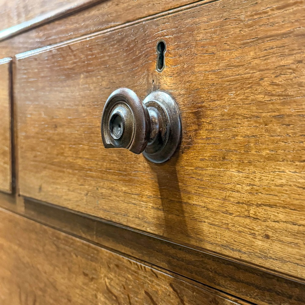 A 19th-century oak linen press featuring a two-door upper cupboard flanked by barley twist columns above a chest of drawers. View XI