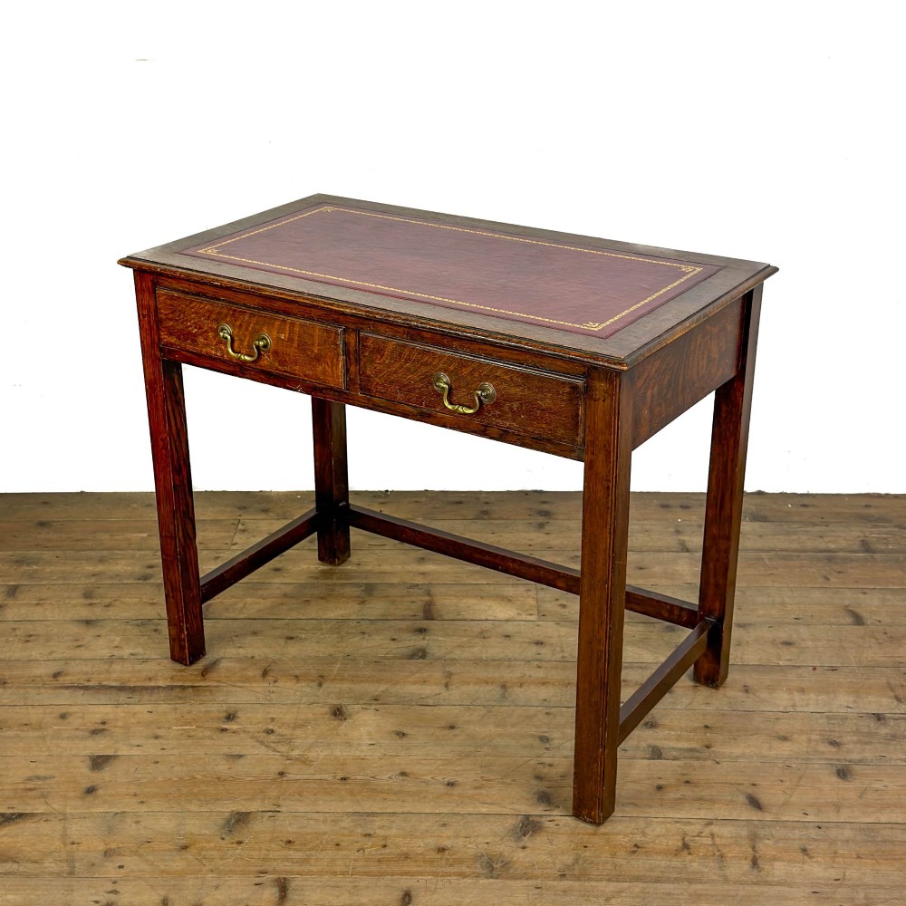 An antique dark oak writing table featuring two frieze drawers with brass drop handles, square legs, and low side stretchers. View II