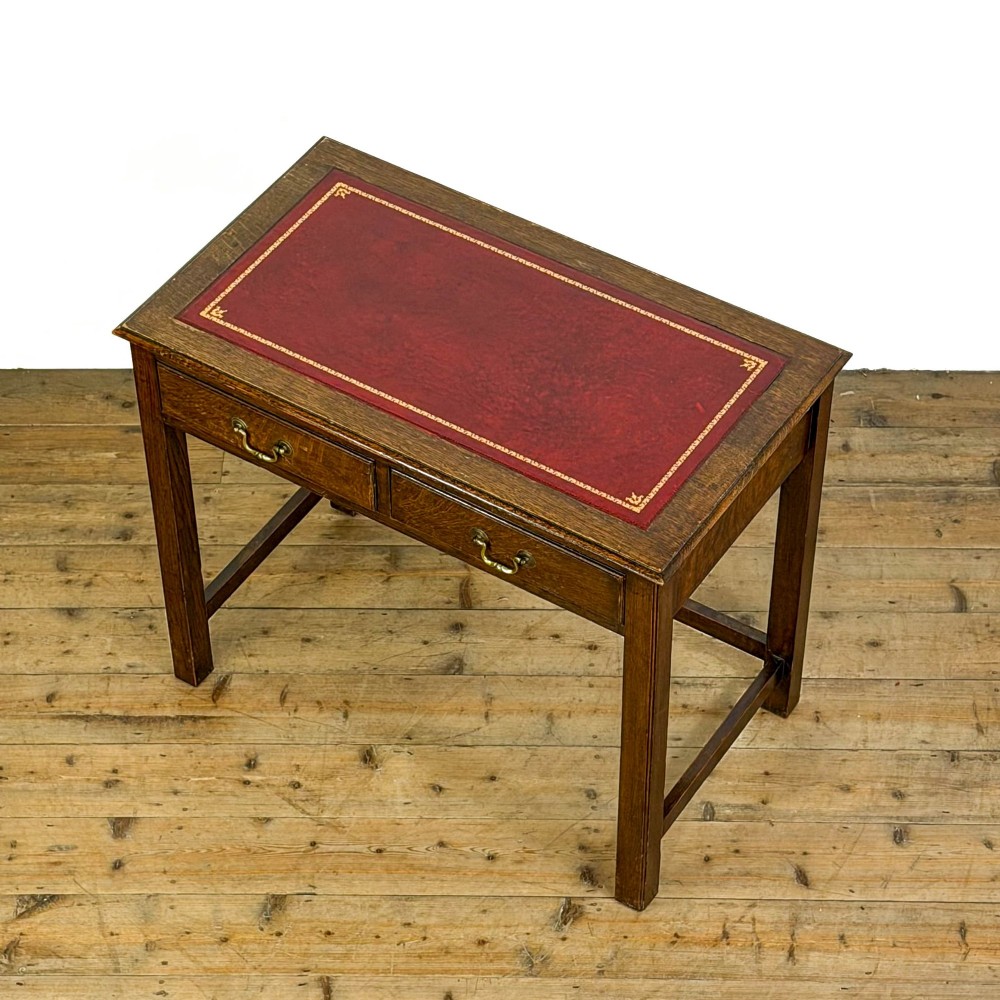 An antique dark oak writing table featuring two frieze drawers with brass drop handles, square legs, and low side stretchers. View III