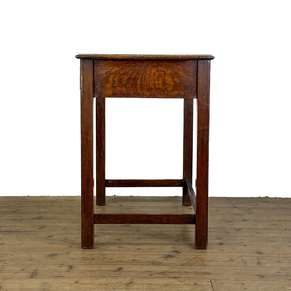 An antique dark oak writing table featuring two frieze drawers with brass drop handles, square legs, and low side stretchers. View IV