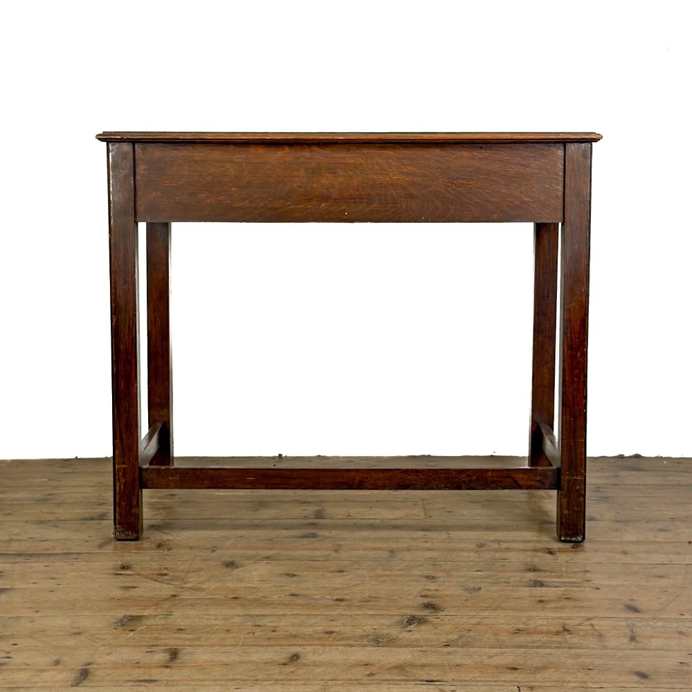 An antique dark oak writing table featuring two frieze drawers with brass drop handles, square legs, and low side stretchers. View V