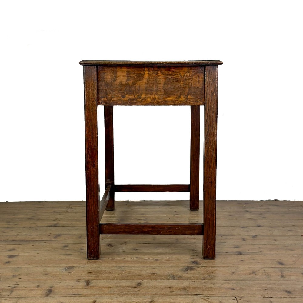 An antique dark oak writing table featuring two frieze drawers with brass drop handles, square legs, and low side stretchers. View VI