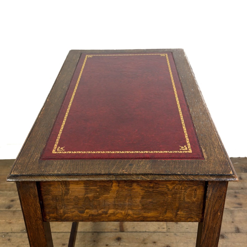 An antique dark oak writing table featuring two frieze drawers with brass drop handles, square legs, and low side stretchers. View VII