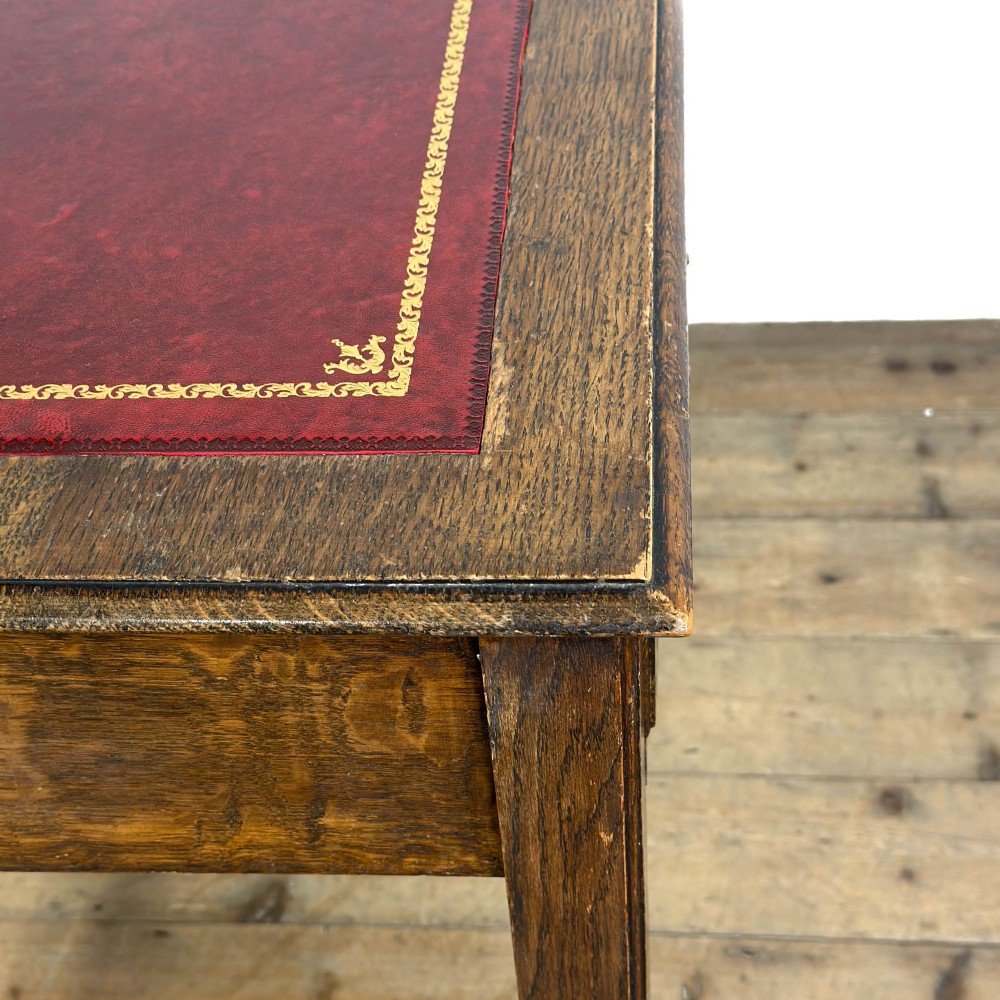 An antique dark oak writing table featuring two frieze drawers with brass drop handles, square legs, and low side stretchers. View VIII