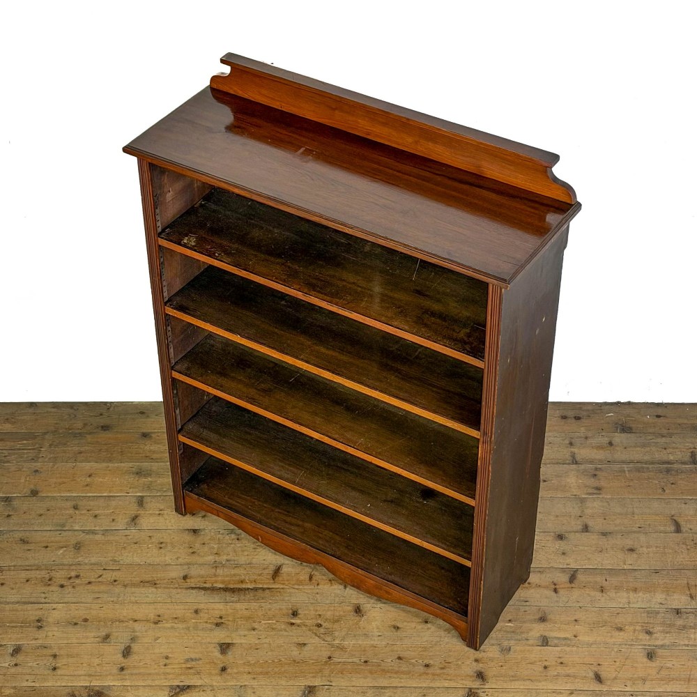 A tall 19th-century open wooden bookcase featuring five fixed shelves, fluted side stiles, a stepped pediment, and a shaped apron base. View III