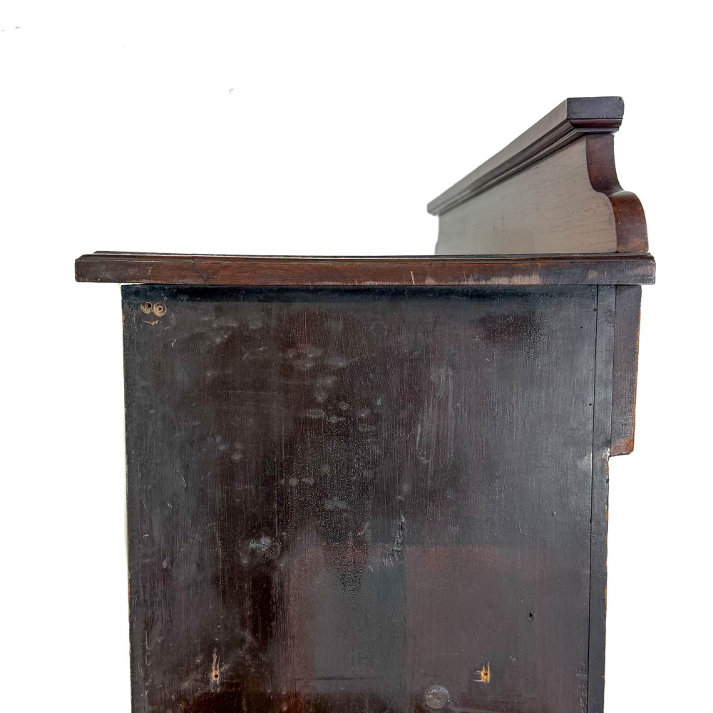 A tall 19th-century open wooden bookcase featuring five fixed shelves, fluted side stiles, a stepped pediment, and a shaped apron base. View V