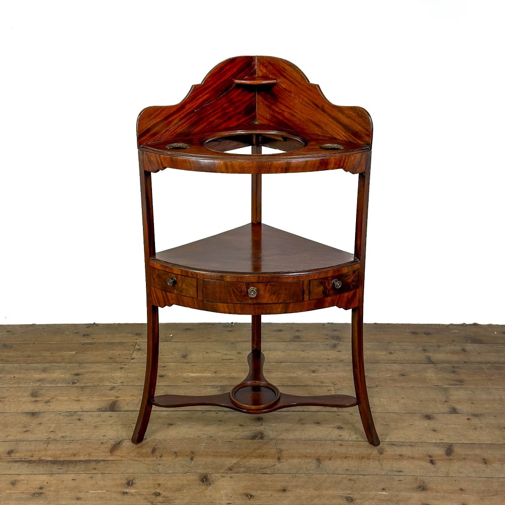 A Georgian mahogany corner washstand featuring a shaped splashback, middle drawer section with brass knobs, and curved splayed legs. View II