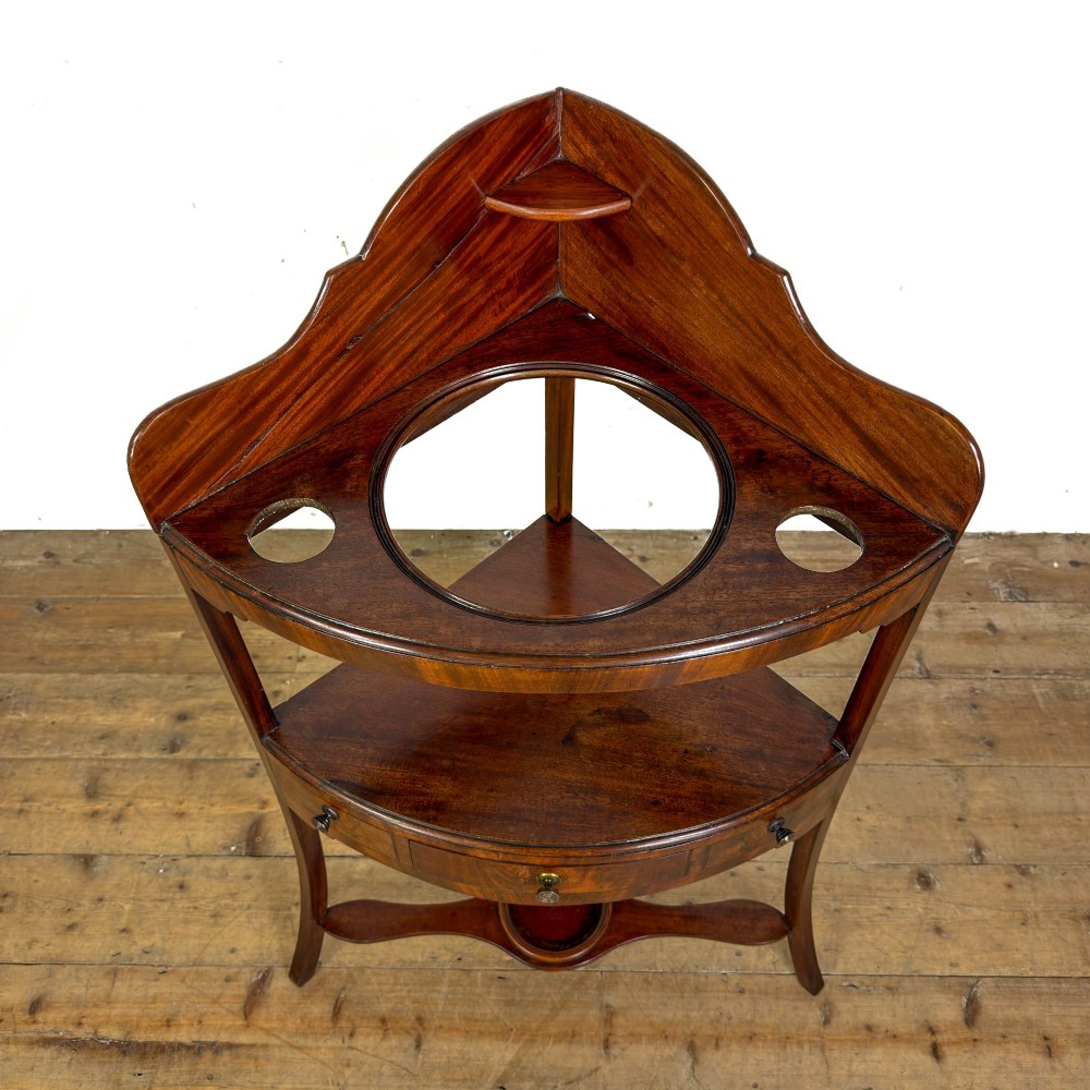 A Georgian mahogany corner washstand featuring a shaped splashback, middle drawer section with brass knobs, and curved splayed legs. View III