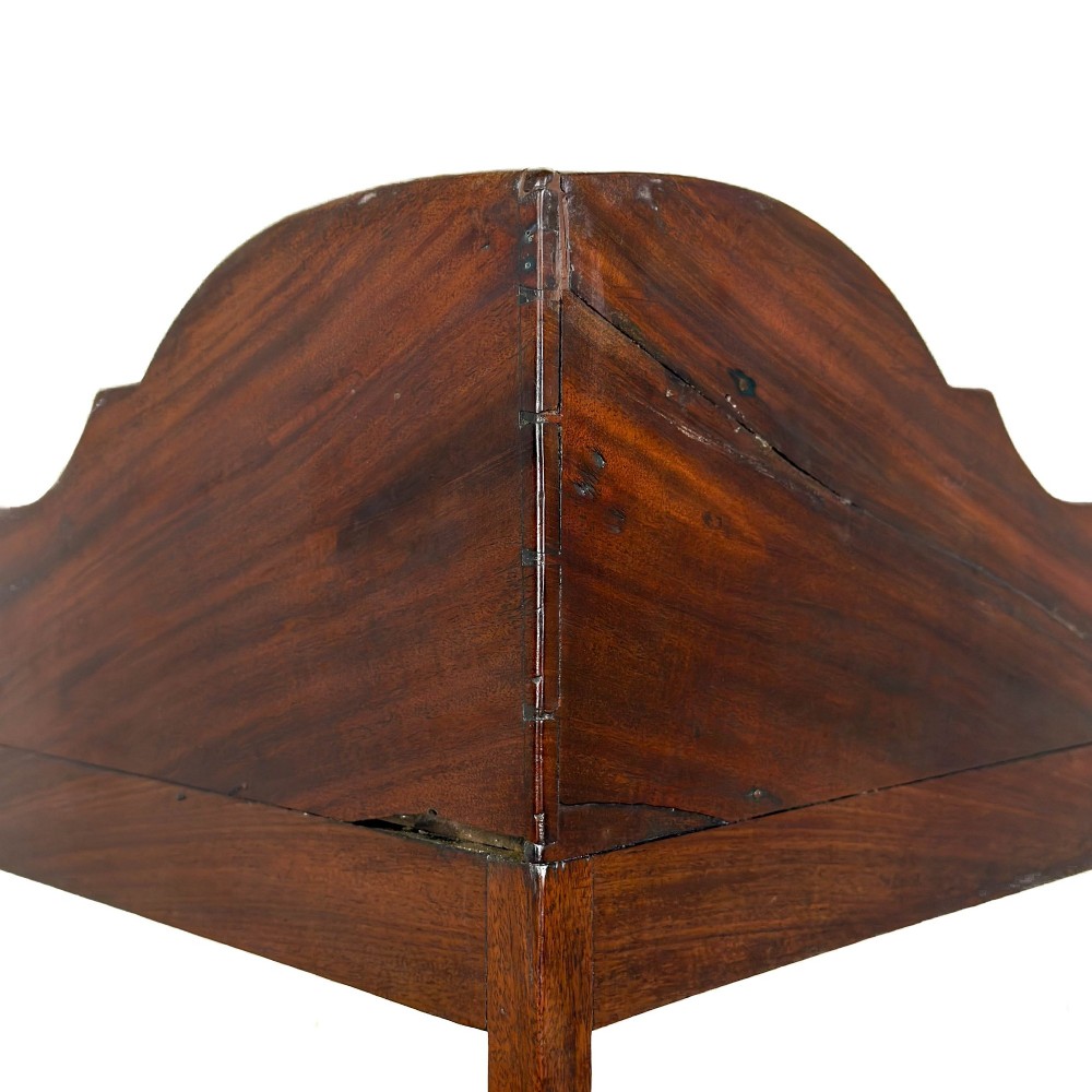 A Georgian mahogany corner washstand featuring a shaped splashback, middle drawer section with brass knobs, and curved splayed legs. View VI