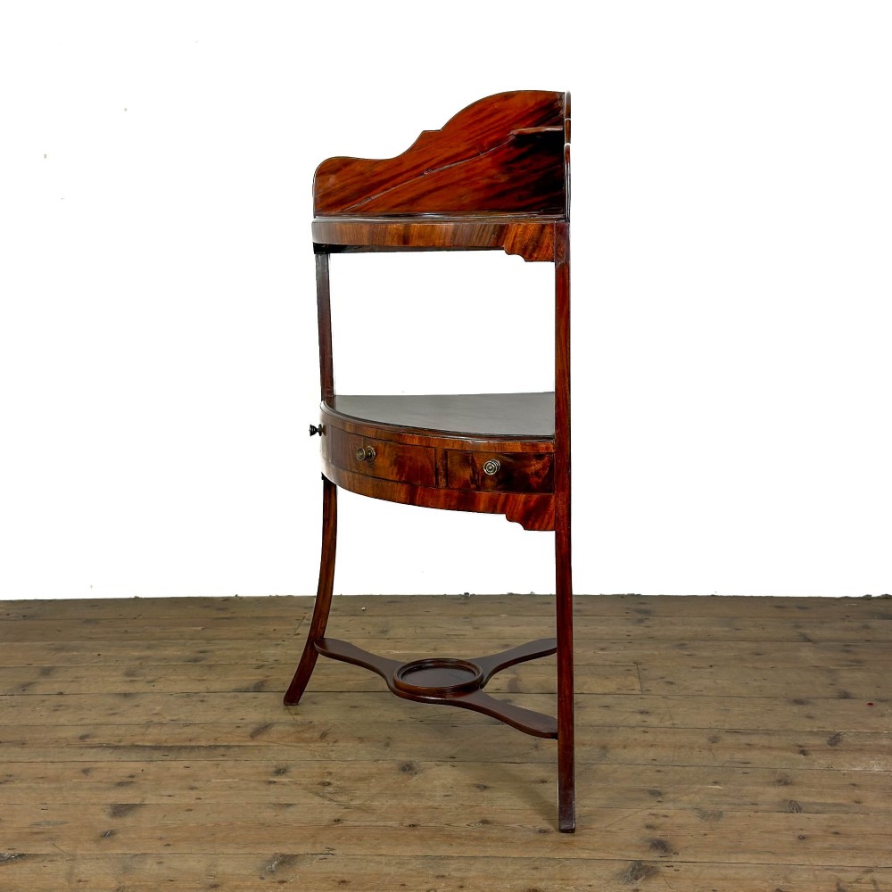 A Georgian mahogany corner washstand featuring a shaped splashback, middle drawer section with brass knobs, and curved splayed legs. View VIII