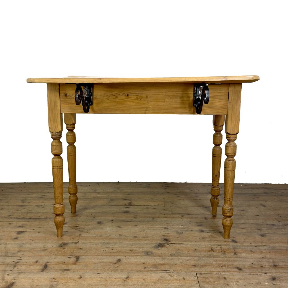 A pine drop leaf kitchen table featuring turned legs and hinged side panels that fold down. View III