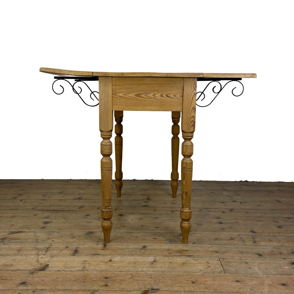 A pine drop leaf kitchen table featuring turned legs and hinged side panels that fold down. View VIII