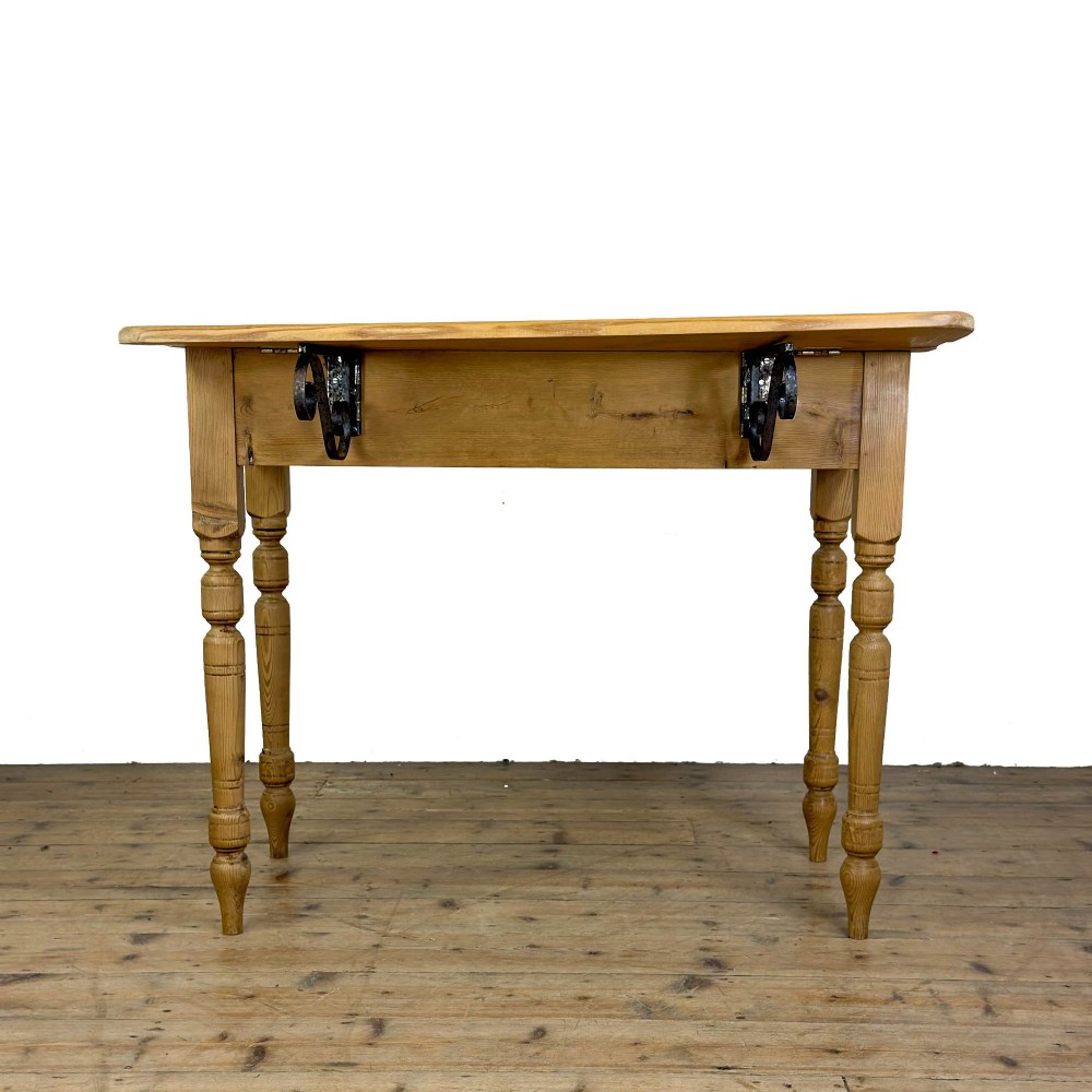 A pine drop leaf kitchen table featuring turned legs and hinged side panels that fold down. View X