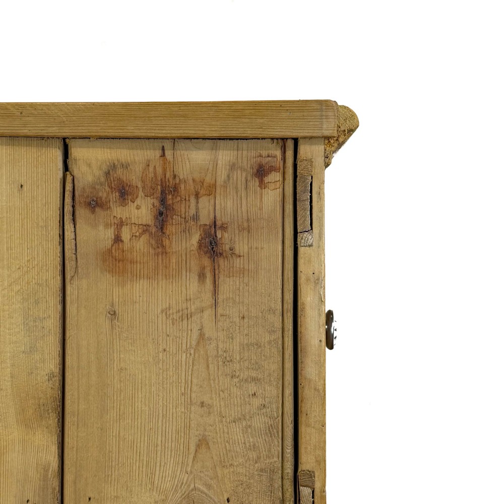 A Victorian pine dresser base with three frieze drawers, ceramic drawer knobs, two panelled cupboard doors, and a central open shelving recess. View X