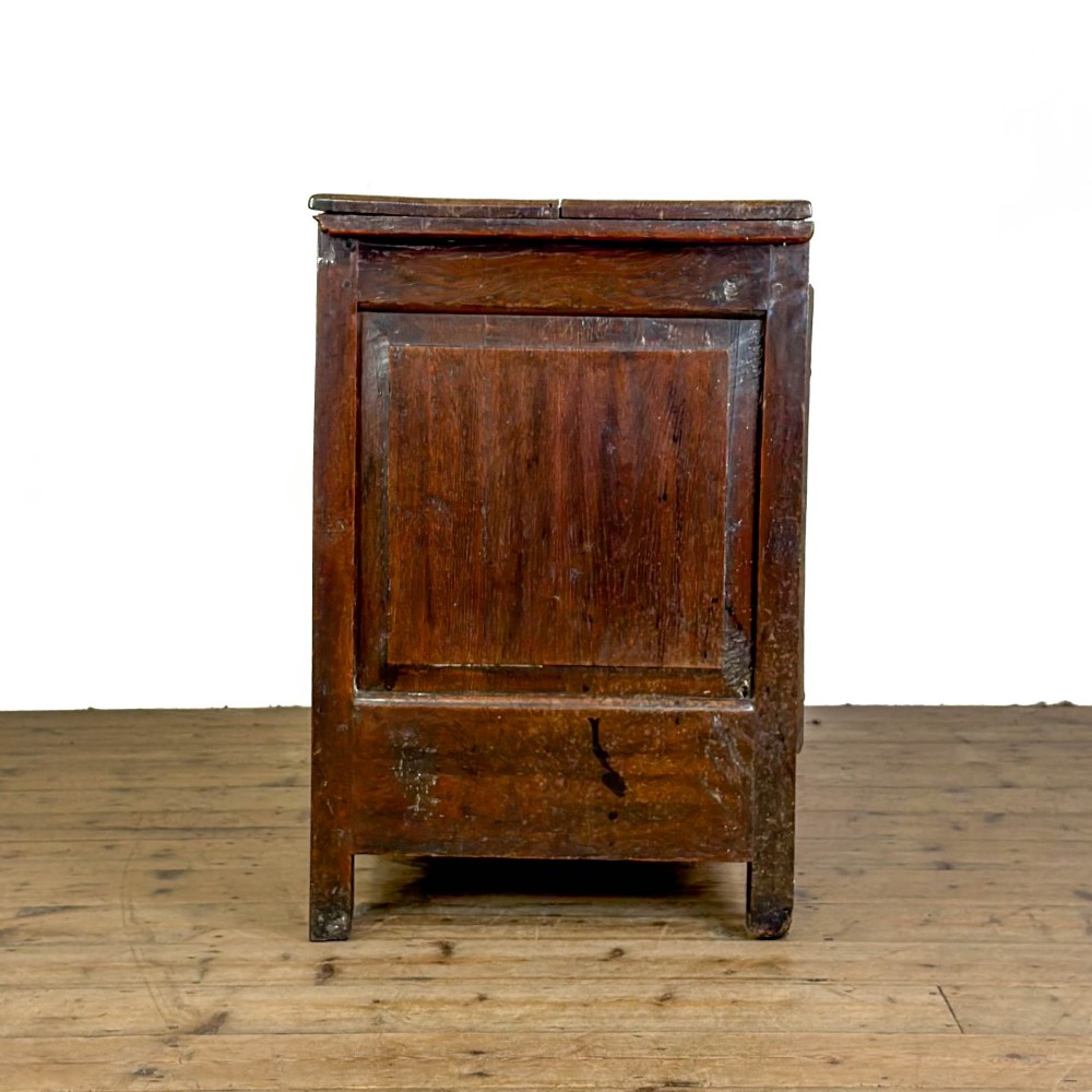 An 18th-century dark oak mule chest featuring three raised fielded panels, two lower drawers with brass swan-neck handles, and carved initial detailing. View VIII