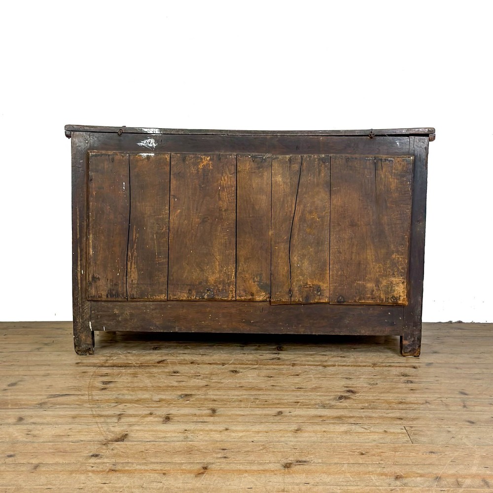 An 18th-century dark oak mule chest featuring three raised fielded panels, two lower drawers with brass swan-neck handles, and carved initial detailing. View IX