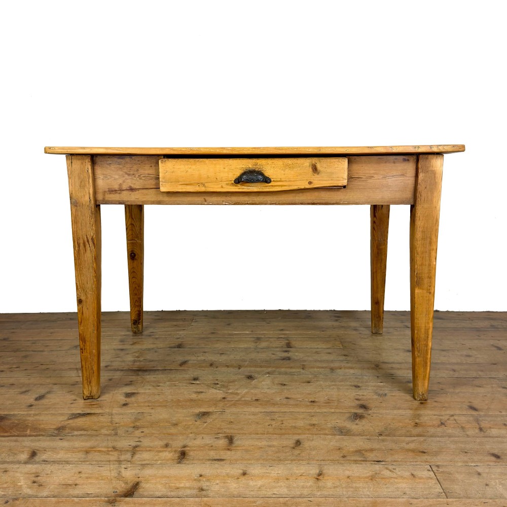 An antique pine kitchen table featuring a plank top, a single apron drawer with a cast iron cup handle, and four tapered square legs. View II