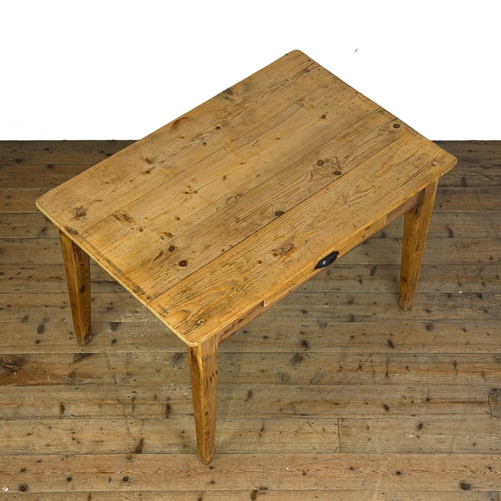 An antique pine kitchen table featuring a plank top, a single apron drawer with a cast iron cup handle, and four tapered square legs. View IV