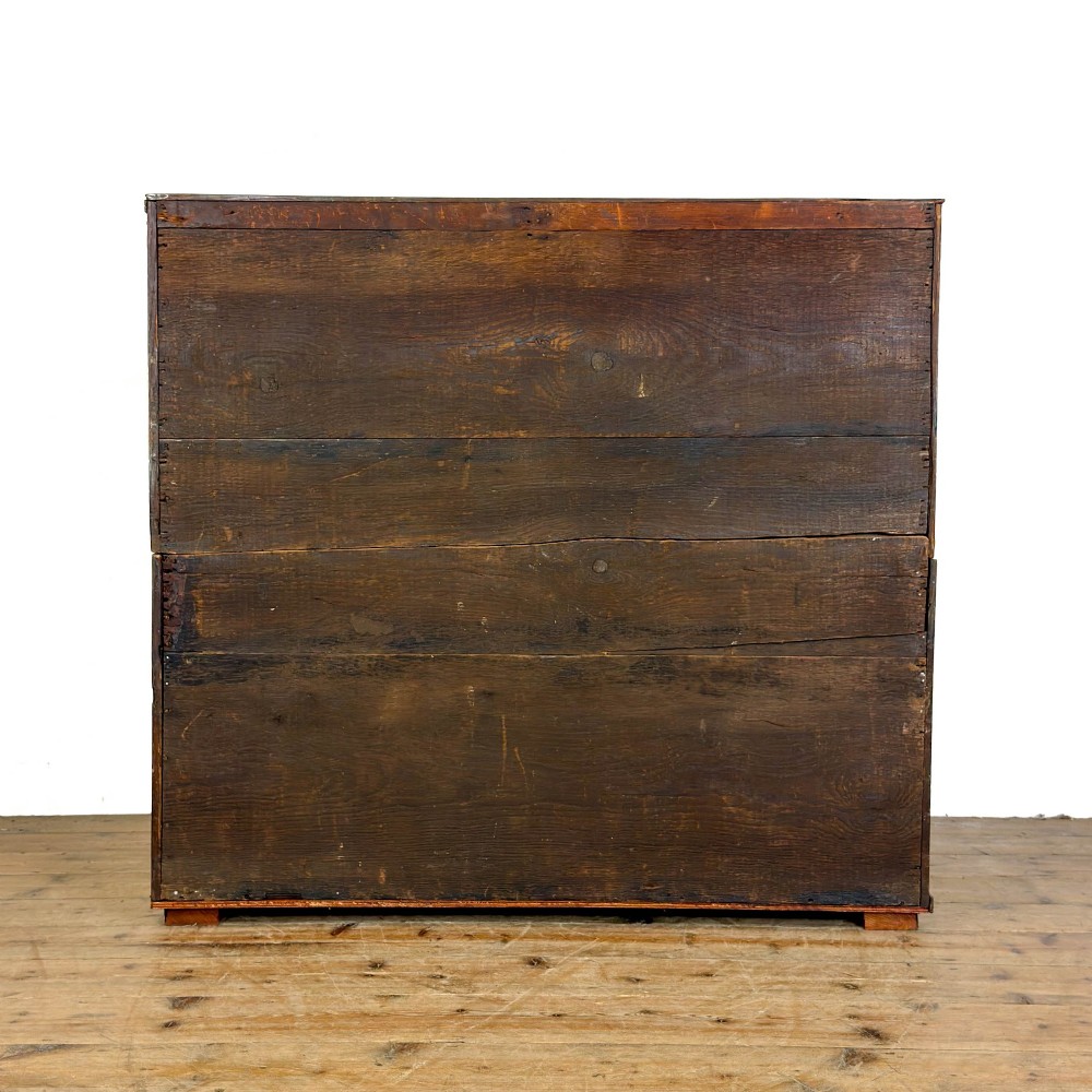 A nineteenth-century oak chest of drawers featuring two short over three long drawers with brass ring handles. View IV