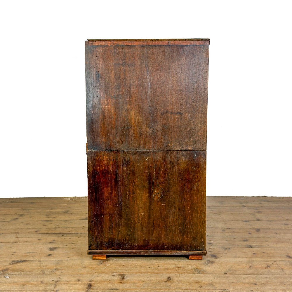 A nineteenth-century oak chest of drawers featuring two short over three long drawers with brass ring handles. View VI
