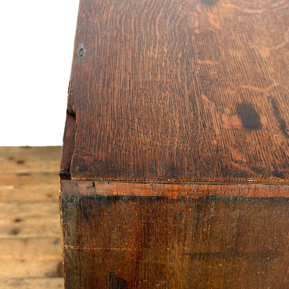 A nineteenth-century oak chest of drawers featuring two short over three long drawers with brass ring handles. View VII