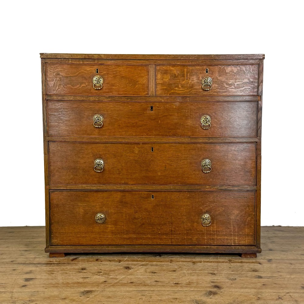 A nineteenth-century oak chest of drawers featuring two short over three long drawers with brass ring handles. View VIII